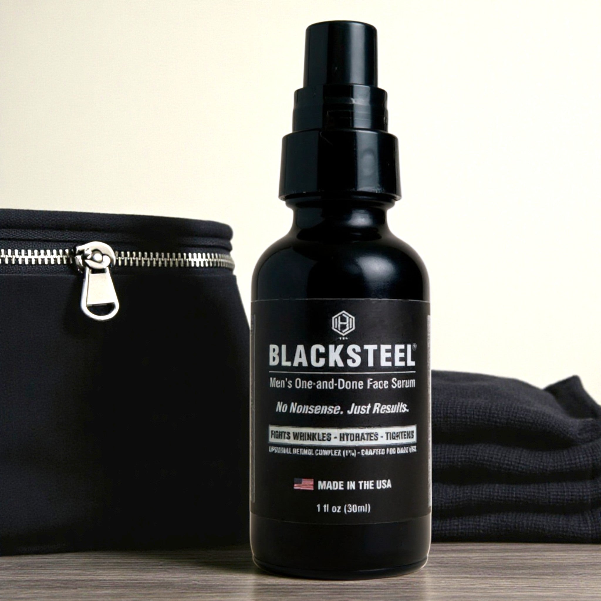 BLACKSTEEL 1 oz. travel size face serum for men shown with toiletry bag and towel